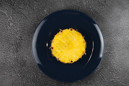 蓝色板块上的菠萝片 黄色热带水果的切片异国甜点凤梨营养果汁饮食饮料植物食物水壶图片
