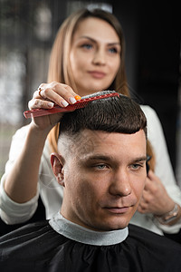女理发师用剪刀在理发店制造发型 理发师修整帅哥的头发胡须发型师潮人女士顾客店铺客户工作剃刀造型师图片