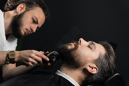 用剃须机修胡须 做理发店和男美容院的广告工作室胡子潮人理发师商业理发绅士大男子男性修剪图片