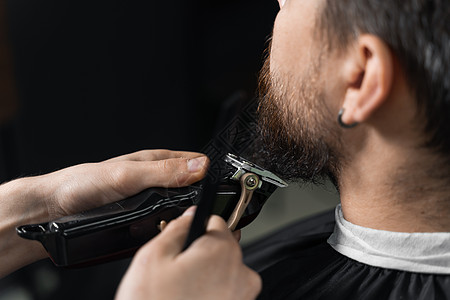 在理发店刮胡子 长着脚镣的理发师修剪英俊胡子的男人主义头发顾客胡须商业绅士男性剃刀潮人黑色图片