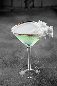 绿色酒精鸡尾酒在一个玻璃杯里装饰 用棉花糖在灰色背景上调酒师餐厅君度酒吧补品果汁棉布玻璃泡沫酊剂图片