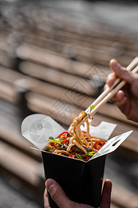 装在黑食品箱里 用筷子盛着辣面条 快送食物服务 外卖的中国街饭木头用餐大豆盒子猪肉蔬菜午餐美食餐厅炒锅图片
