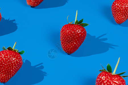 蓝底的草莓成熟水果 新鲜红莓果实图片
