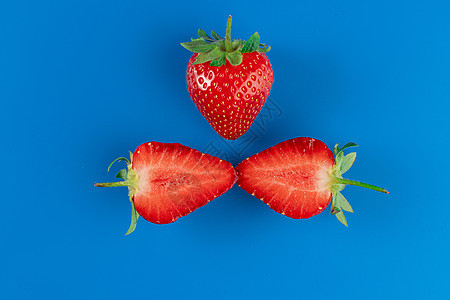 草莓切片贴近和整片蓝底的草莓 季节性贝利团体收成维生素红色蓝色绿色食物味道花园桌子图片