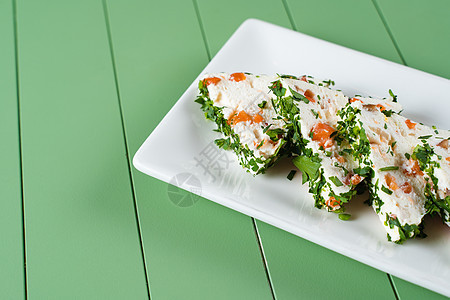 在绿色背景的白色盘子上 甜美的软奶油奶酪小吃 加三文鱼和草药早餐蔬菜小屋食物饮食营养沙拉红鱼养分节食图片