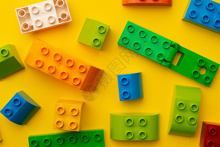 分散在黄色背景的小孩玩具构建器细节Name游戏幼儿园工具构造婴儿收藏童年立方体塑料玩具图片