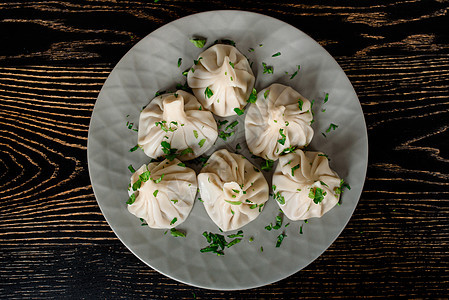 Khinkali 传统的格鲁吉亚烹饪 在灰色盘子上装饰香肠猪肉餐厅香料美食食物羊肉辣椒洋葱面团牛肉图片