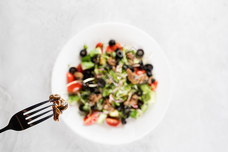 白色背景的绿色沙拉附近叉子上爬着葡萄蜗牛 法国美食美味烹饪叶子食物餐厅绿色田螺饮食螺旋蜗牛图片