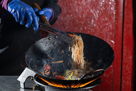 Funchoza饭面和蔬菜烹饪在wokpan点火街道油炸食物洋葱大豆平底锅厨房红烧餐厅炒锅图片