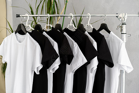 挂在架子上的黑白T恤推介会织物纺织品黑色服装衣服打印推广品牌白色图片