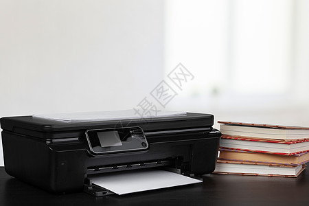 架在桌上的压缩家庭打印机 书面模糊背景的书籍职场文档黑色激光打印桌面办公室工作商业扫描器图片