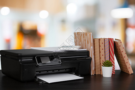 在模糊背景下堆放书本和家用打印机扫描黑色文档职场桌面电子产品激光复印件文书工作图片