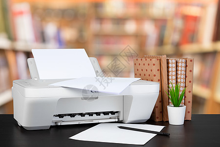 架在桌上的压缩家庭打印机 书面模糊背景的书籍桌面扫描器黑色职场桌子打印墨水办公室文档扫描图片