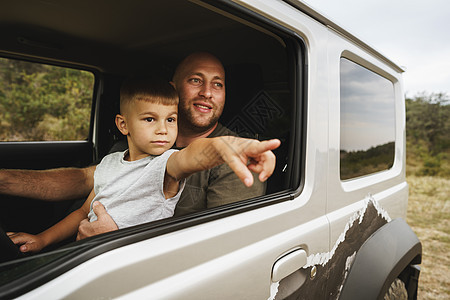 父亲教小儿子在路上开车旅行活动爸爸教学乐趣男性父母驾驶男生家庭运输图片