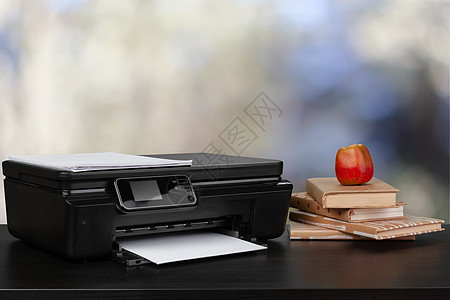在模糊背景下堆放书本和家用打印机职场复印件文档桌子电子产品黑色技术复印机办公室桌面图片