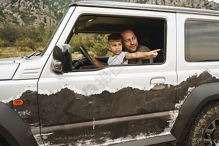 父亲教小儿子在路上开车旅行身份男性活动孩子微笑父母驾驶假期成人青少年图片
