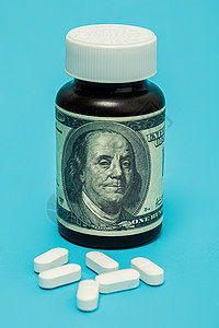 蓝色背景上的白色钱和药丸 医疗费用上涨 保险医药的概念 保险成本高 药品成本高疾病过敏诊所处方关心药物胶囊治疗价格金融图片