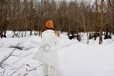 年轻女子走在冬季田野景观户外娱乐周围有很多雪图片