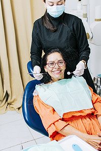 牙医为微笑的病人检查口腔 女牙医为女病人做根管治疗 女牙医和说谎的病人 牙医进行口腔科护理程序药品医学医生设备牙齿牙科治疗健康图片