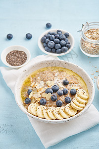 含蓝莓的燕麦 蓝光背景的香蕉黄油蜂蜜勺子碳水奶制品谷物麦片食物化合物木头图片