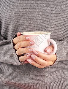 冷秋天清晨工作时喝热咖啡 手拿着杯子 酒 灰色毛衣 粉红修指甲 闭合 垂直图片