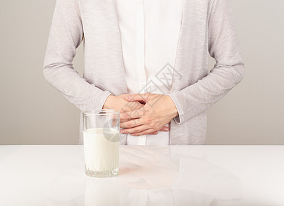女人旁边的一杯牛奶 有坏胃痛玻璃乳糖腹泻痛苦症状发酵胀气肠胃食物过敏图片