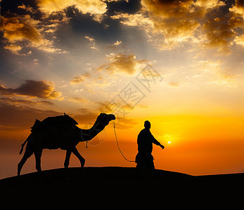 在沙漠沙丘带骆驼的骆驼骆驼司机图片