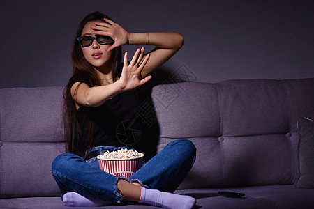 亚裔妇女看电视和吃爆米花沙发微笑头发电影女孩震惊女性女士快乐乐趣图片
