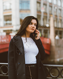 长头发的女人正在打电话 秋天或冬天 户外的女孩 圣彼得堡市中心靠近桥的街道上漂亮聪明的褐发女郎 复制空间电话商务女性蓝色成人城市图片