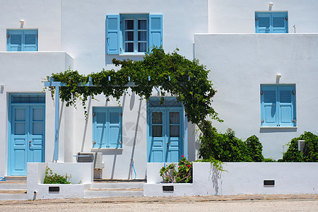 传统的希腊传统建筑房屋漆白白色 有蓝色门和窗帘的玻璃百叶窗出口细节街道窗户村庄入口建筑学图片