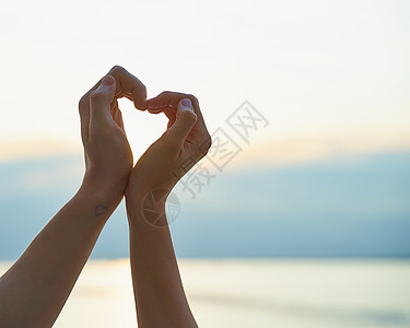 海洋之心钻石女性和男性的手露出心脏 爱的象征 海滩背景背景