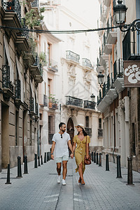 戴着帽子和黄色礼服的女孩和她留胡子的男朋友在散步幸福夫妻男人景观街道微笑旅行旅游古董历史性图片
