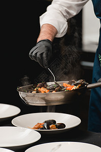 厨师准备一份海鲜菜 煎锅里有海鲜 柠檬和烤肉 虾鱿鱼和白贝类拼盘炙烤动物食物小吃甲壳油炸烧烤餐厅美食图片