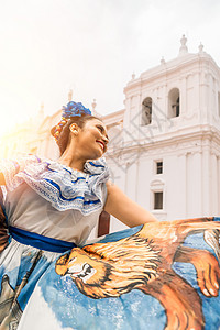 一位身着尼加拉瓜传统服饰的拉丁女性在殖民地教堂前跳舞的垂直照片 拉丁美洲的文化和传统概念图片