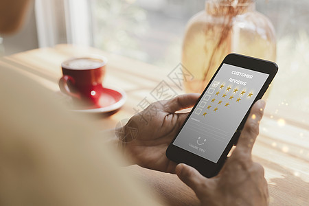 女性手持智能手机选择五星级图标 以给服务带来满意度 对咖啡店的印象非常深刻  infoFlickr图片