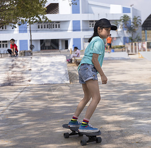 早上 亚洲小女孩在公园滑板坡道上玩冲浪滑板 快乐的女孩在公园玩滑板 体育活动生活方式概念娱乐极限女士闲暇滑冰享受女性乐趣运动街道图片