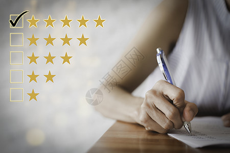女手用笔填写问卷 客户满意度问卷 五星级评价 勾选五颗星的方框 积极的情绪客户反馈背景图片