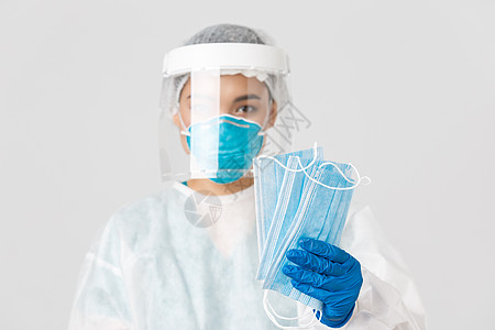 Covid19 冠状病毒病 医护人员的概念 身着个人防护装备的亚洲女医生特写为患者提供医用口罩以确保安全 白色背景社交专家套装疾图片