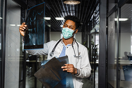非洲医生在诊所检查X光片 戴医疗面具的黑人学生正在研究和看Ct扫描 校对 Soup成人工人快乐办公室x射线学习卫生男人顾问男性图片