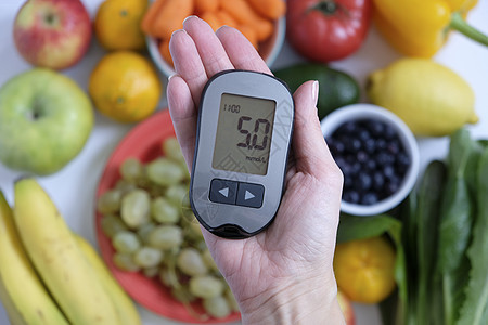 糖尿病概念 手持葡萄测量仪和健康食品 营养导致糖尿病病症图片