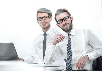 两名商业人士在办公桌旁就座玻璃文档合作经理桌子员工团队职业笔记本电脑图片