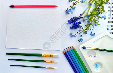 白色背景上的平躺速写本和粉色紫色 蓝色 紫色和绿色铅笔 艺术桌面视图照片图片