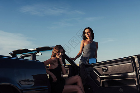 街上拍着两个漂亮女孩的相片女孩们阳光旅行运输友谊驾驶乐趣冒险朋友微笑图片