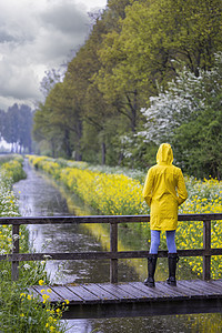 春生带黄雨衣和橡胶靴的年轻女青年衣服天气橡皮雨鞋下雨裙子季节女性女孩鞋类图片