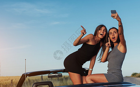 街上拍着两个漂亮女孩的相片阳光乐趣女性女朋友女士自由冒险快乐友谊运输图片
