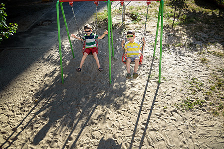 两个小男孩在户外游乐场玩得开心乐趣享受婴儿男孩们快乐孩子们晴天家庭兄弟姐妹孩子图片