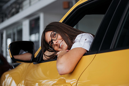 年轻女士在她的新车里笑着微笑速度公路旅行晴天窗户乐趣汽车女孩假期女性图片