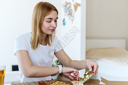 在厨房吃披萨的漂亮女人的肖像 错误的食物 快餐的概念闲暇命令味道服务幸福女孩送货成人女士午餐图片