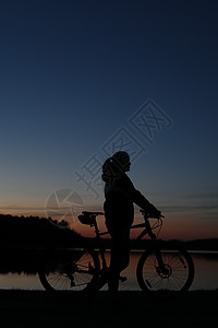蓝色蓝天日落背景多彩的 骑着山上自行车的妇女的休眠轮闲暇旅行自由海岸活动娱乐女士天空墙纸享受图片