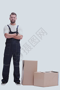 身穿长裤的男子站在箱子旁边 在白色上被隔离图片